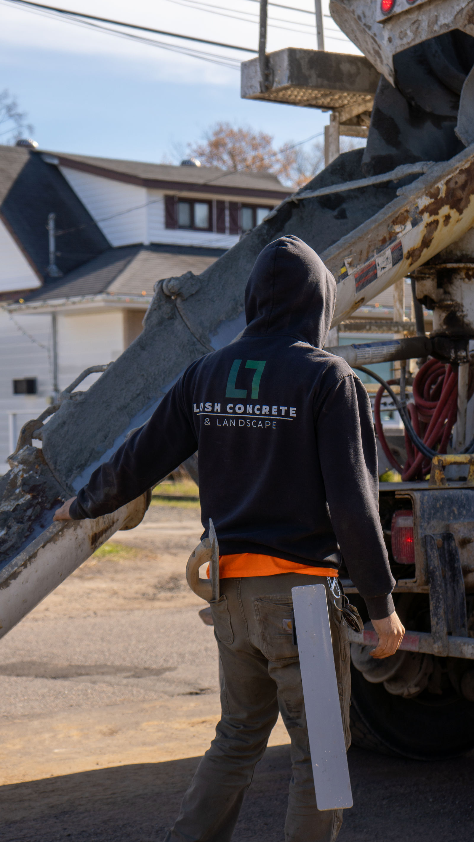 Under the mixer chute, guiding the pour