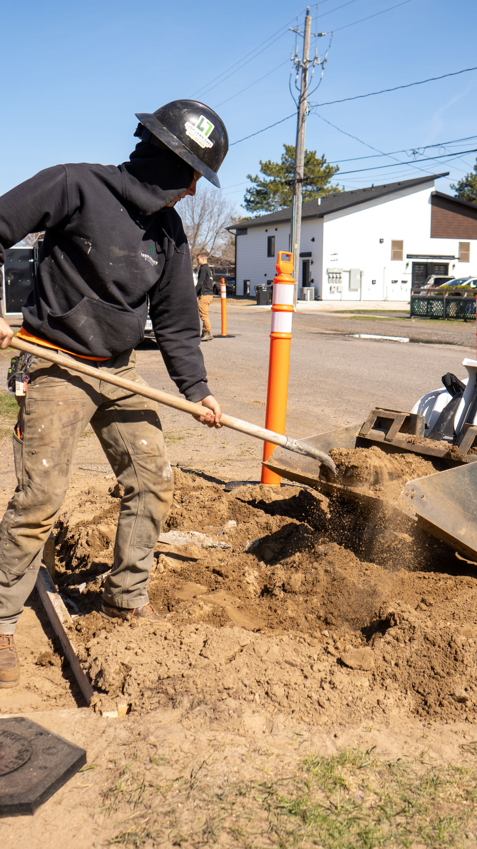 Shoveling fill into the trench