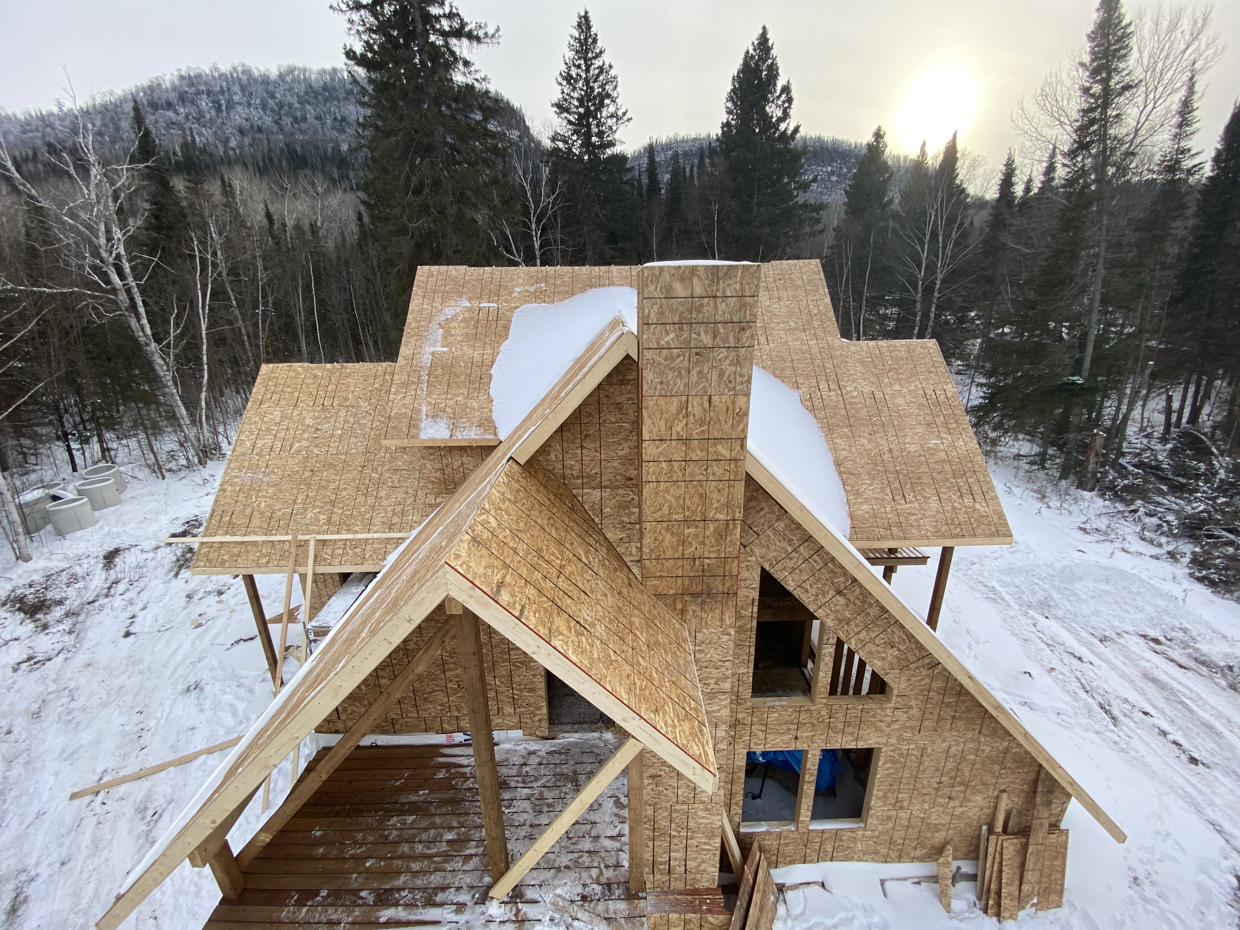 Full OSB shell with chimney chase and cantilevered decks, winter site