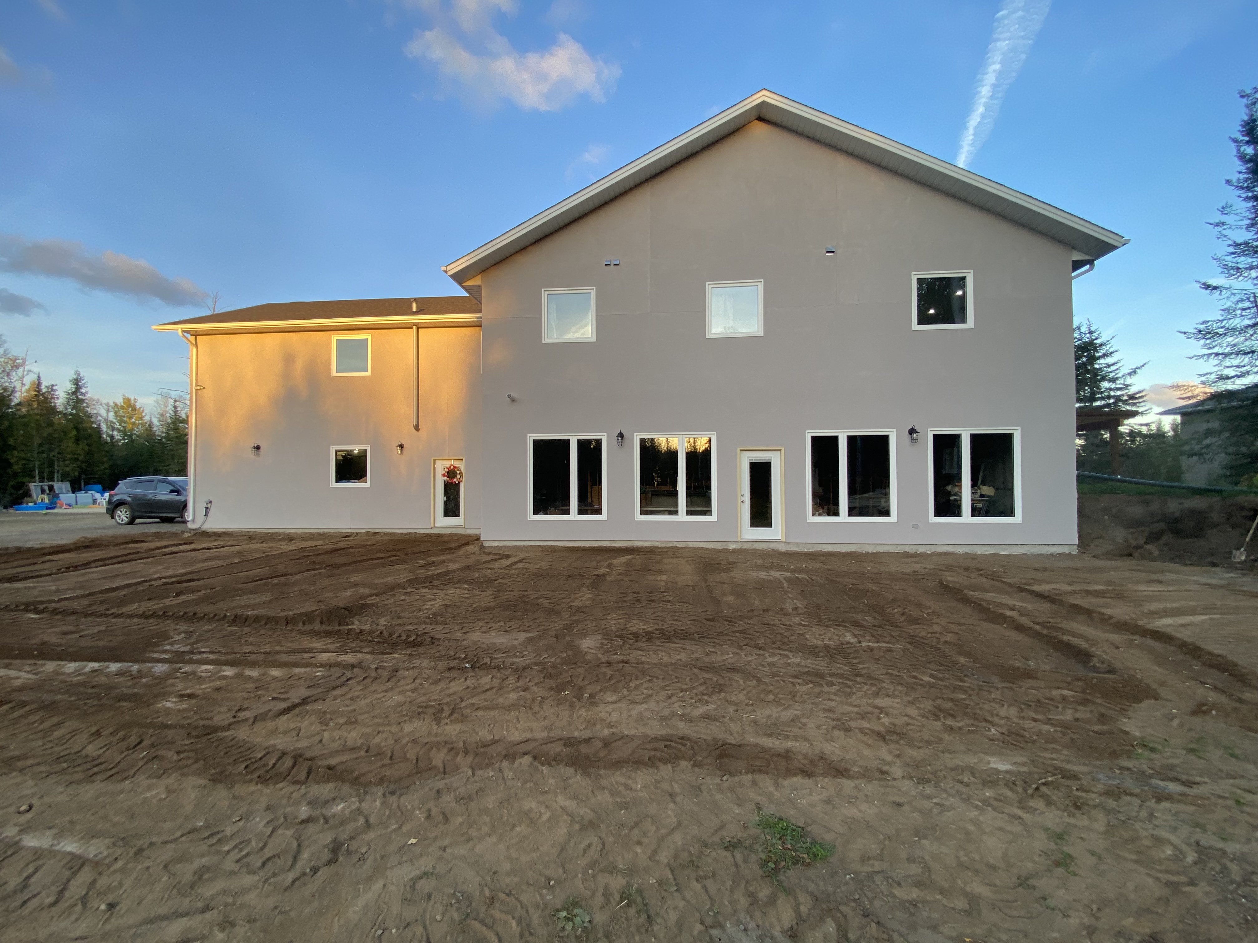 Finished stucco exterior of the completed lake home at dusk