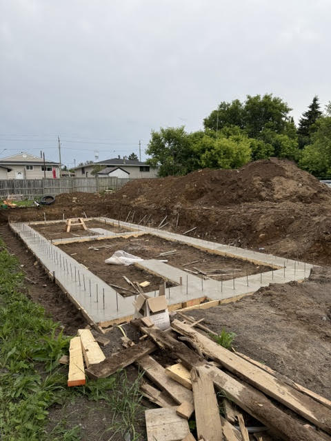 Poured concrete foundation walls with rebar, ready for backfill