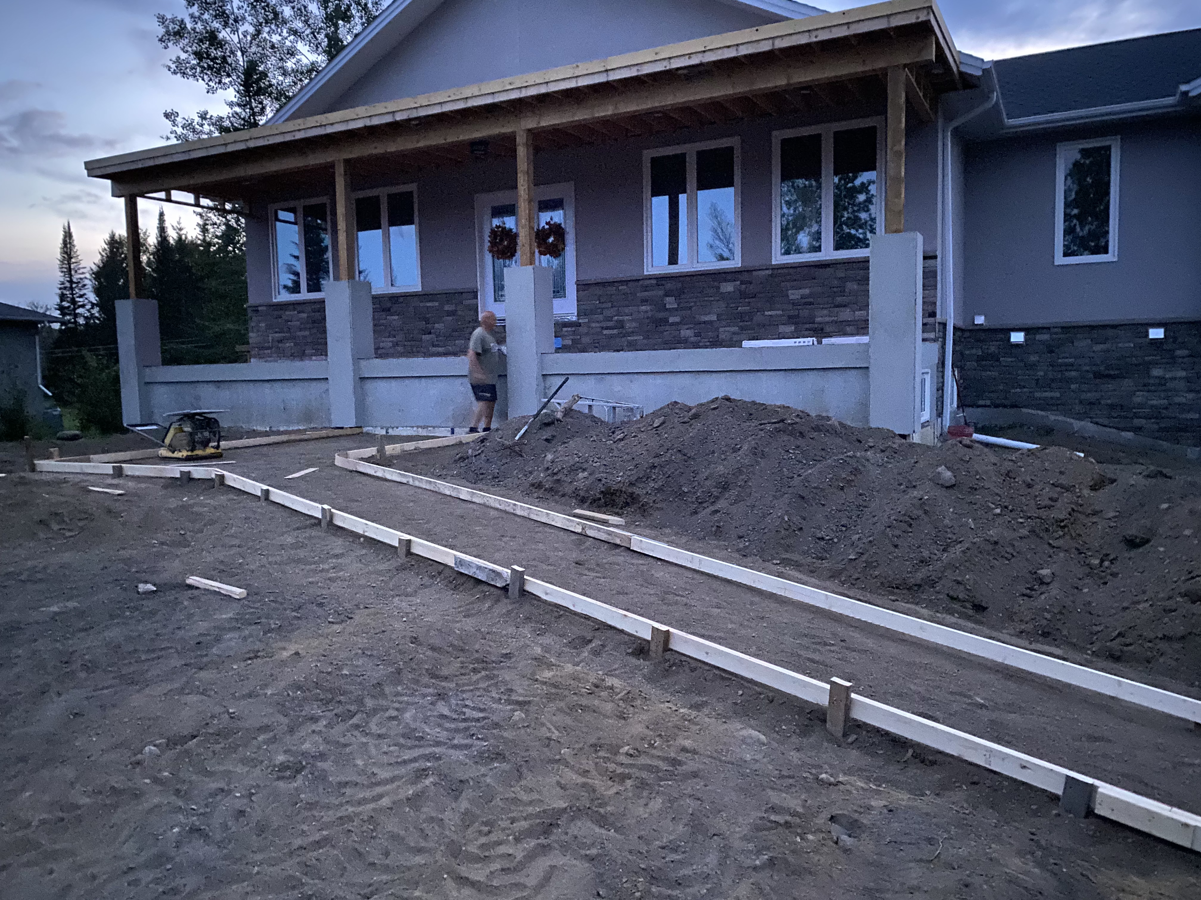 Two-storey lake home — timber truss entry and garage wing fully sheathed