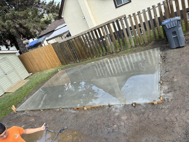Fresh backyard pad pour, floated and curing at a Thunder Bay home